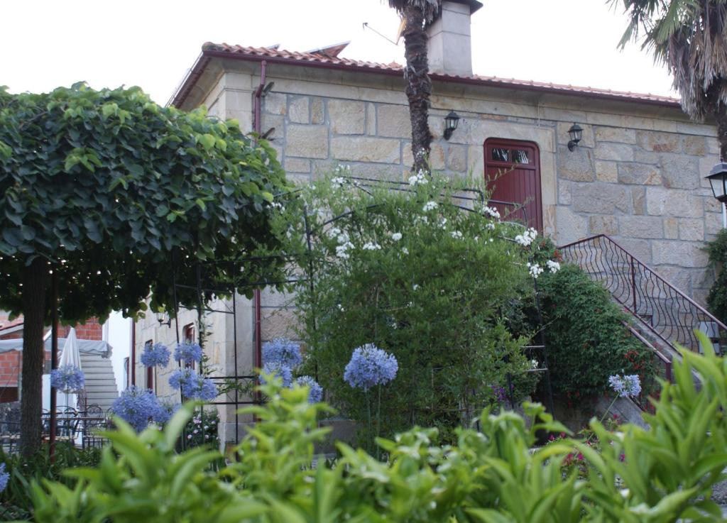 A fachada de granito da Quinta de Canhões, entre agapantos e árvores
